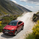 A red Mercedes GLE Coupe driving on a mountain road